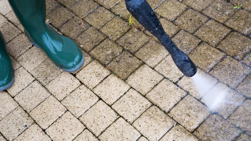 Verschmutzte Pflastersteine werden mit dem Hochdruckreiniger gereinigt